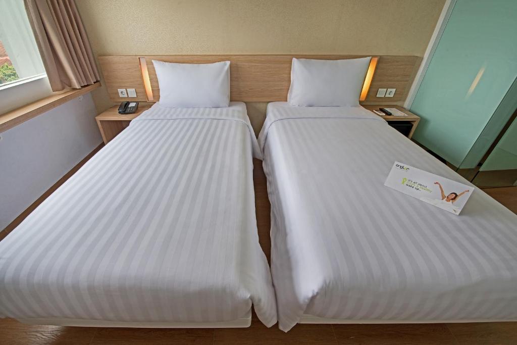Postel nebo postele na pokoji v ubytování Whiz Prime Hotel Pajajaran Bogor