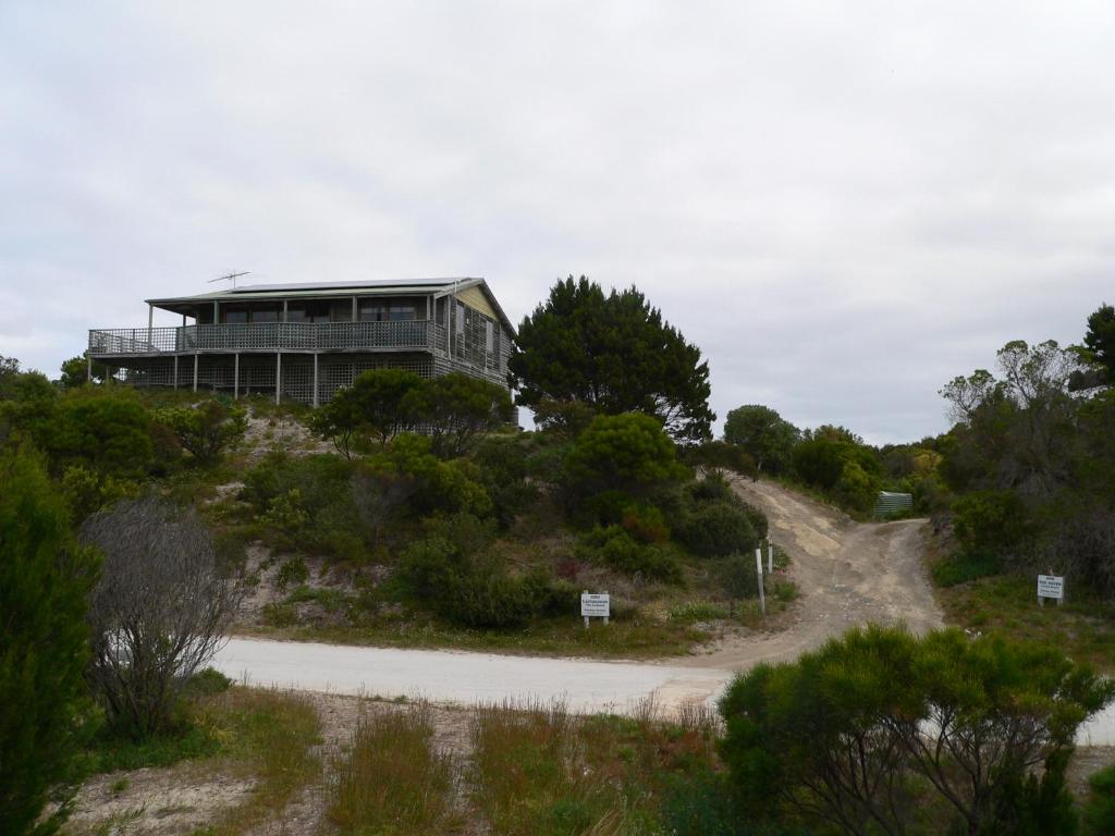 a building on top of a hill with a dirt road at Lantauanan - The Lookout in Island Beach