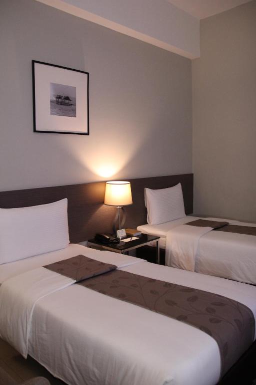 um quarto de hotel com duas camas e um candeeiro em Sequoia Hotel em Manila