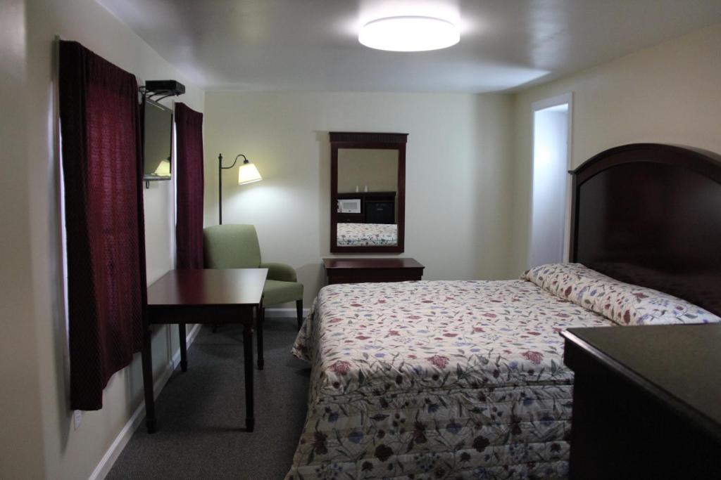 ミドルタウンにあるPleasant Hill Motelのベッドとデスクが備わるホテルルームです。
