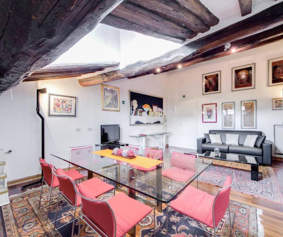 a dining room with a glass table and pink chairs at AltanaParlamento in Rome