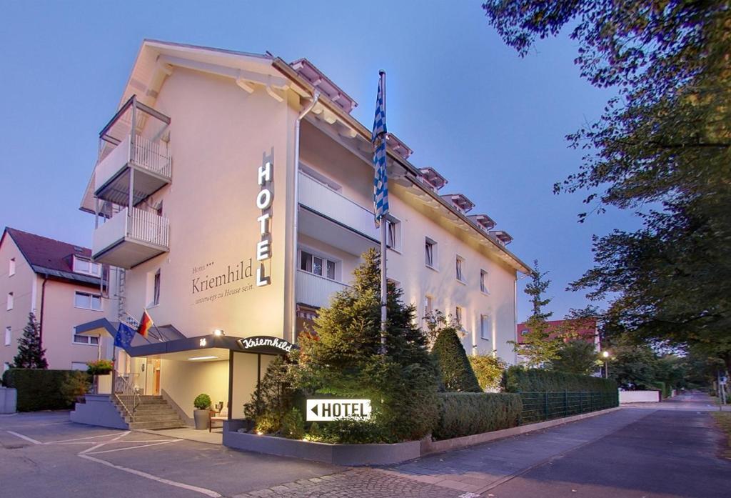 a hotel building with a sign in front of it at Hotel Kriemhild am Hirschgarten in Munich