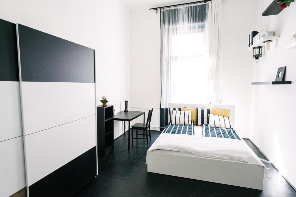 ブダペストにあるd.Five Stylish Apartment on Váci Streetのベッドルーム1室(ベッド1台、テーブル、窓付)