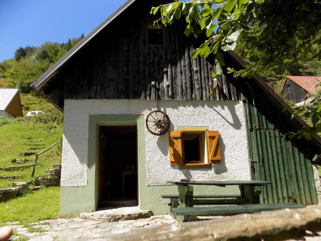 a building with a window and a table in front of it at Holiday Home Na planini in Tolmin