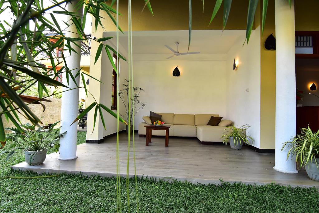 un salon avec un canapé sur la terrasse dans l'établissement Park Lane 88 Apartments, à Negombo
