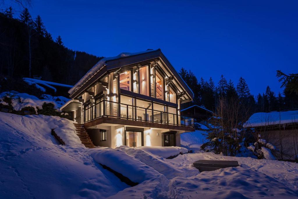 a house is covered in snow at night at Chalet La Source - Chamonix All Year in Chamonix