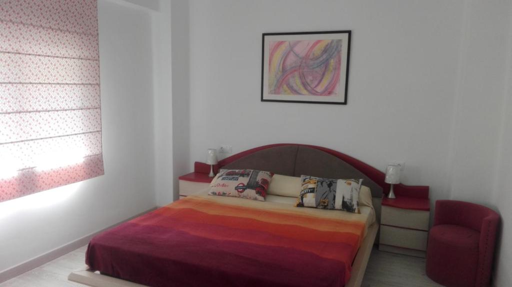 1 dormitorio con 1 cama y 1 silla roja en Apartamento Jardín de Ayora en Valencia