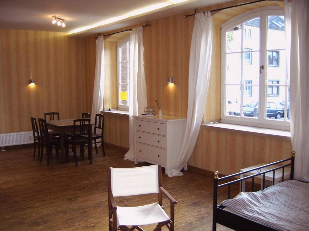 a bedroom with a table and chairs and a window at Wohnung Nikolaiblick in Wismar