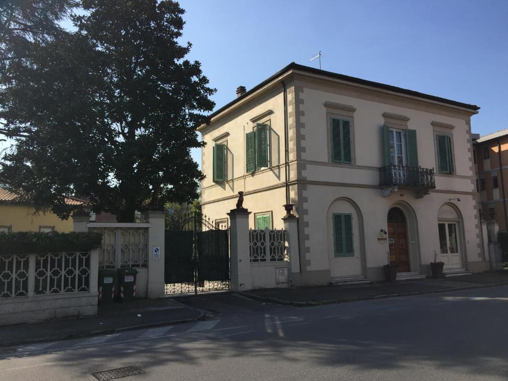 una casa blanca con una valla y un árbol en Lucca Relais, en Lucca