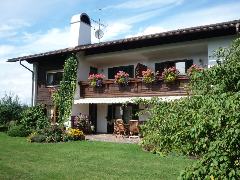 une maison dotée d'un balcon avec des chaises et des fleurs dans l'établissement Landhaus Lotte, à Halblech