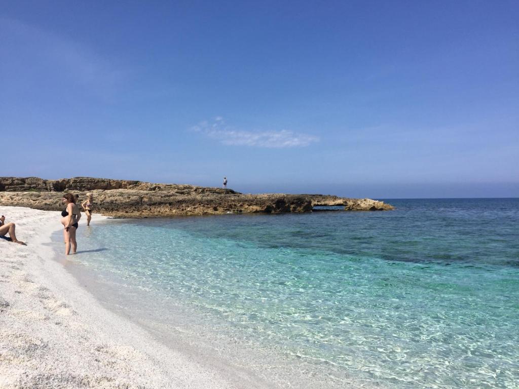 un grupo de personas de pie en una playa en Villa Candida, en Baratili San Pietro