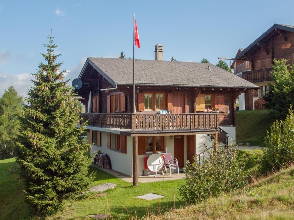 a large house with a deck on a hill at Chalet Allegra in Rosswald
