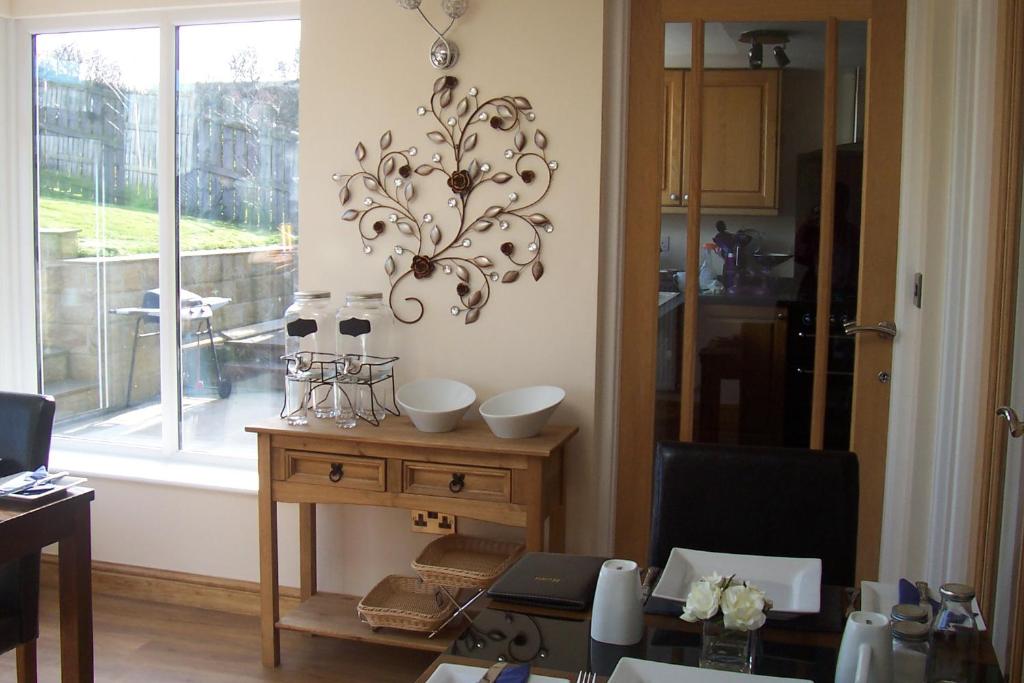a dining room with a table and a chandelier on the wall at Lazy Days in Whitby