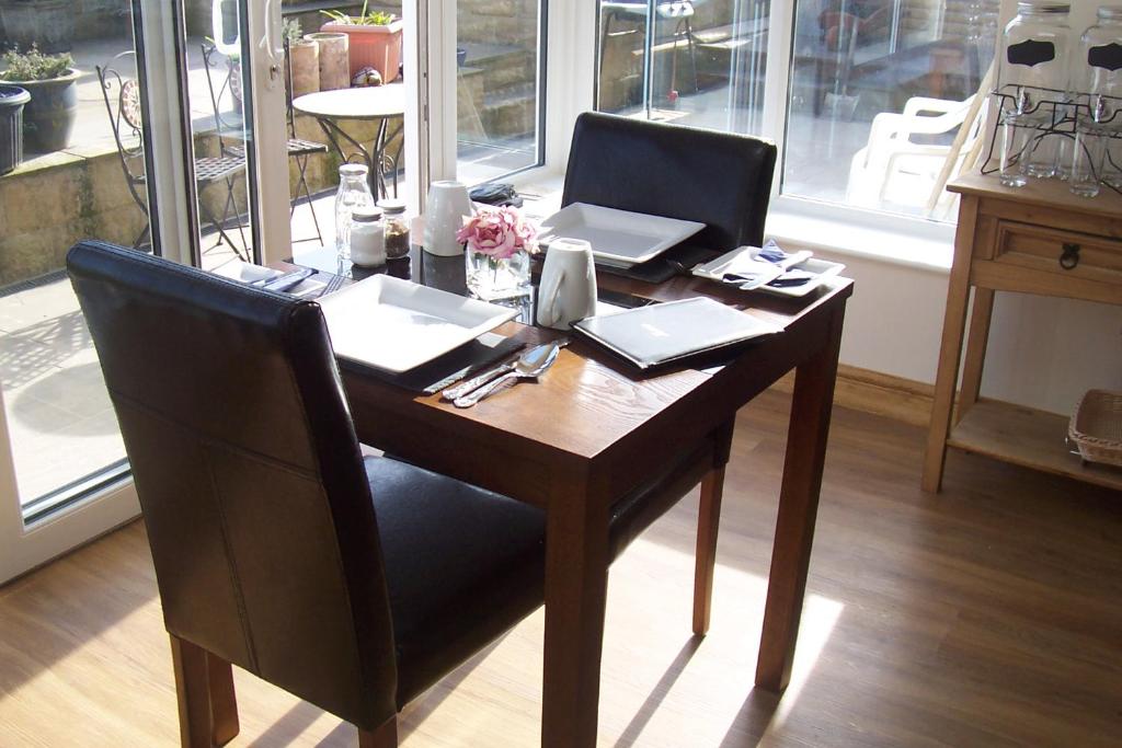 a wooden table with two chairs and a laptop on it at Lazy Days in Whitby