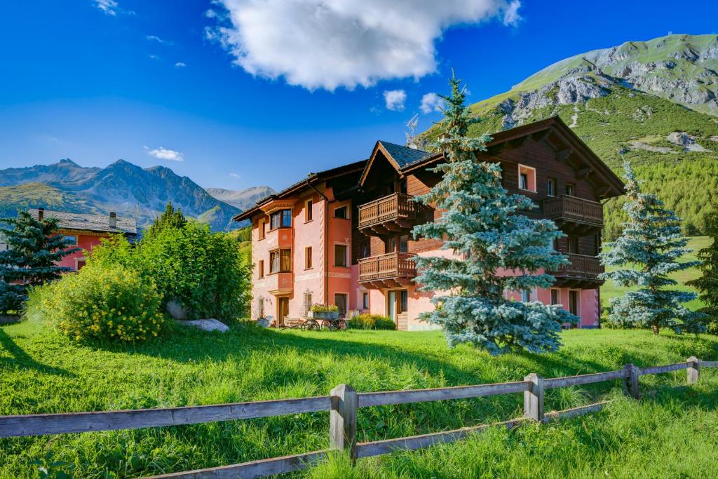 una casa in montagna con una recinzione di Residence Bait da Mott a Livigno