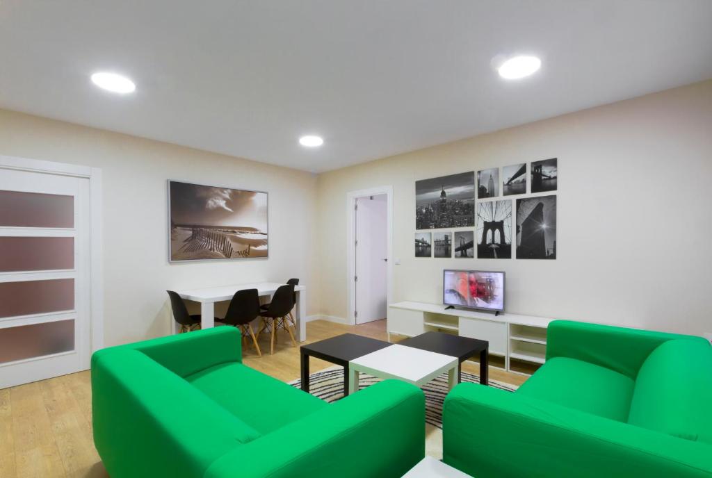 a living room with green chairs and a table at Apartamento Plazalema in Zamora