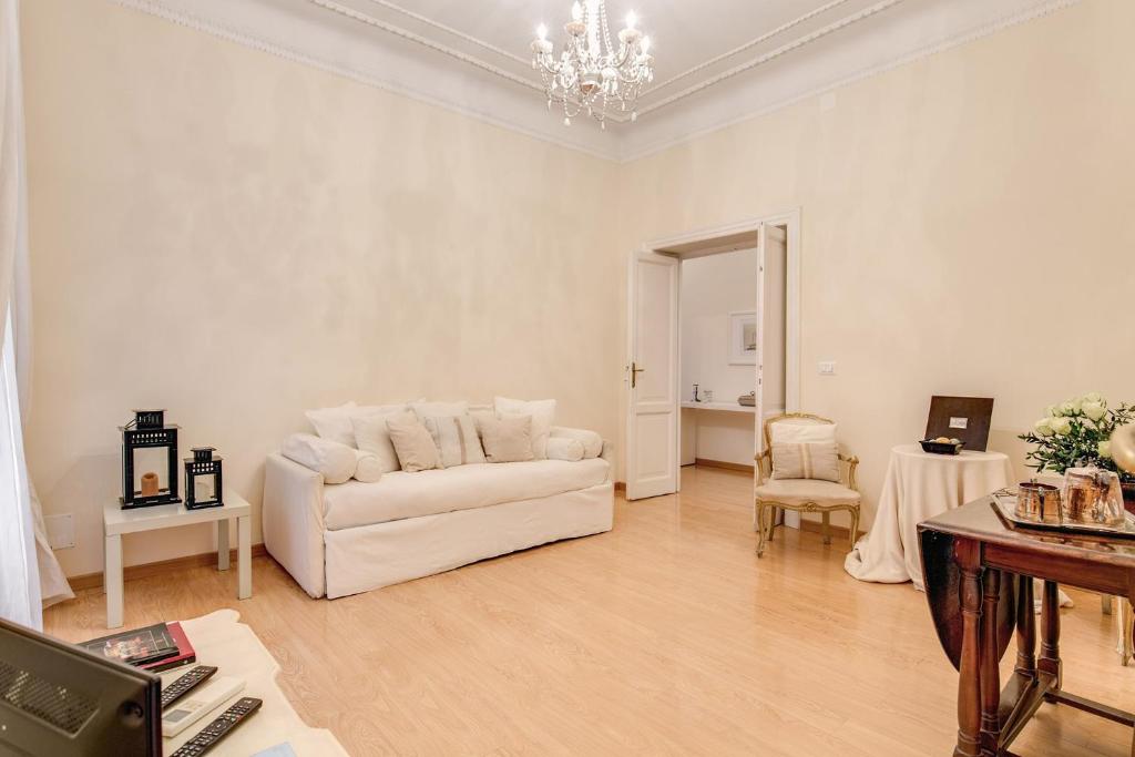 sala de estar con sofá blanco y mesa en RHH Rome Holiday Home, en Roma