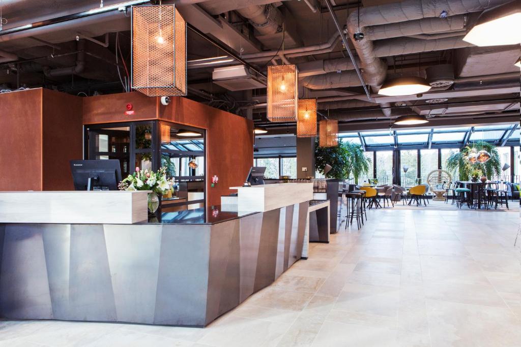 a lobby with a bar with tables and chairs at Quality Hotel Winn Haninge in Haninge