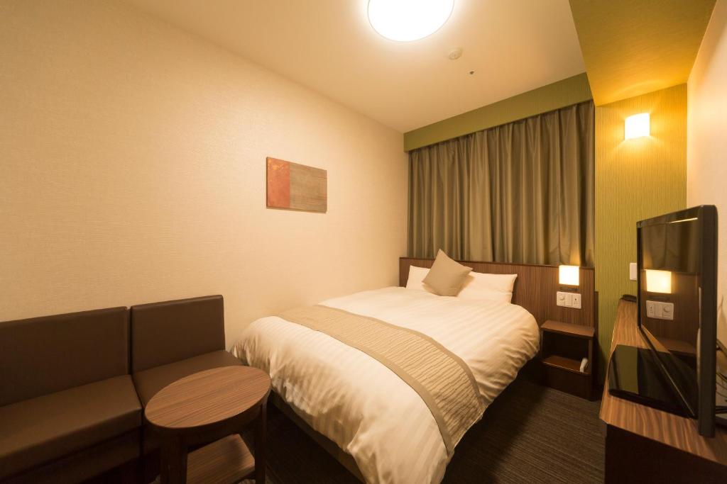 Postel nebo postele na pokoji v ubytování Myoujin-no-Yu Dormy Inn Premium Kanda