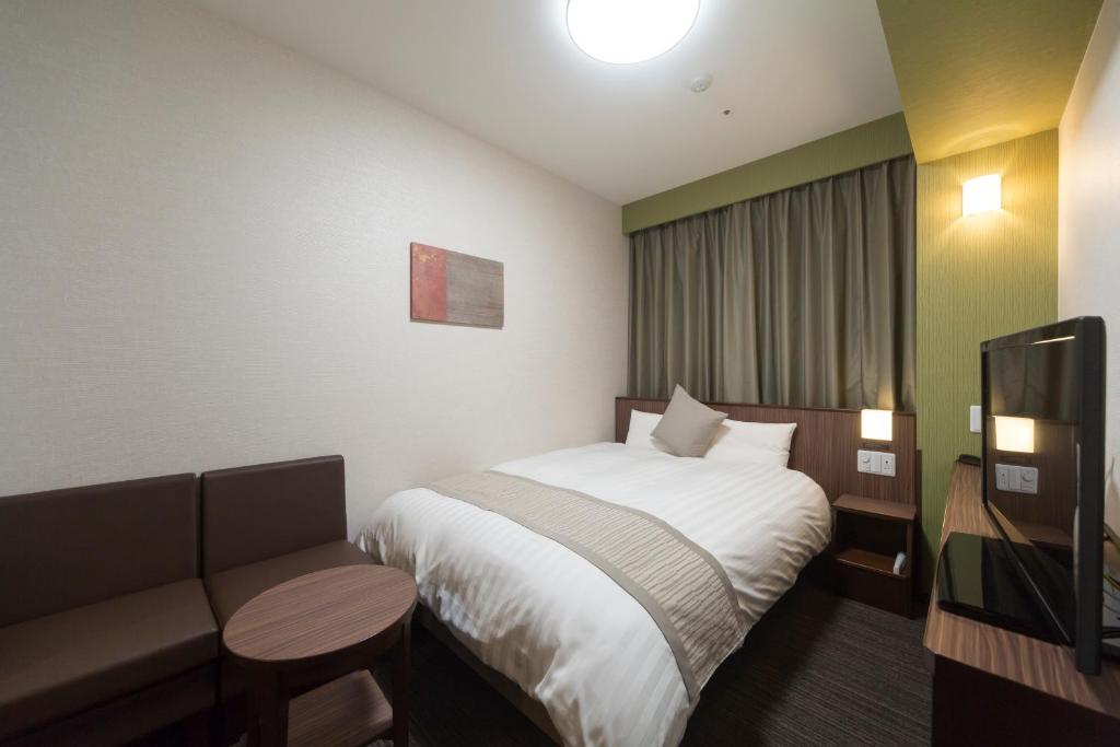 Postel nebo postele na pokoji v ubytování Myoujin-no-Yu Dormy Inn Premium Kanda