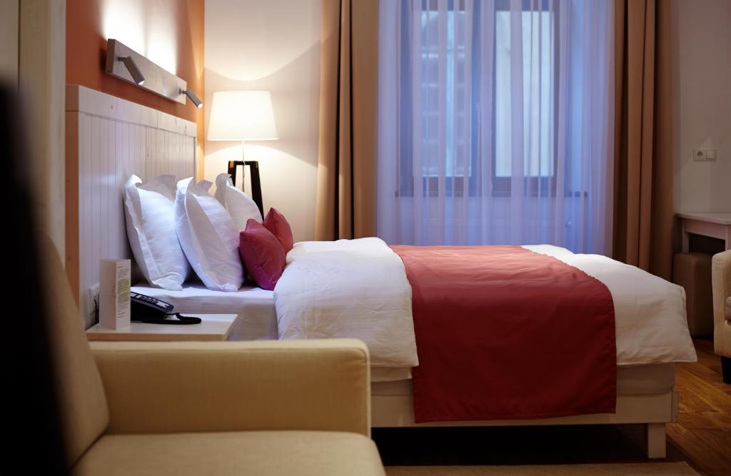 Rudolfo Hotel tesisinde bir odada yatak veya yataklar