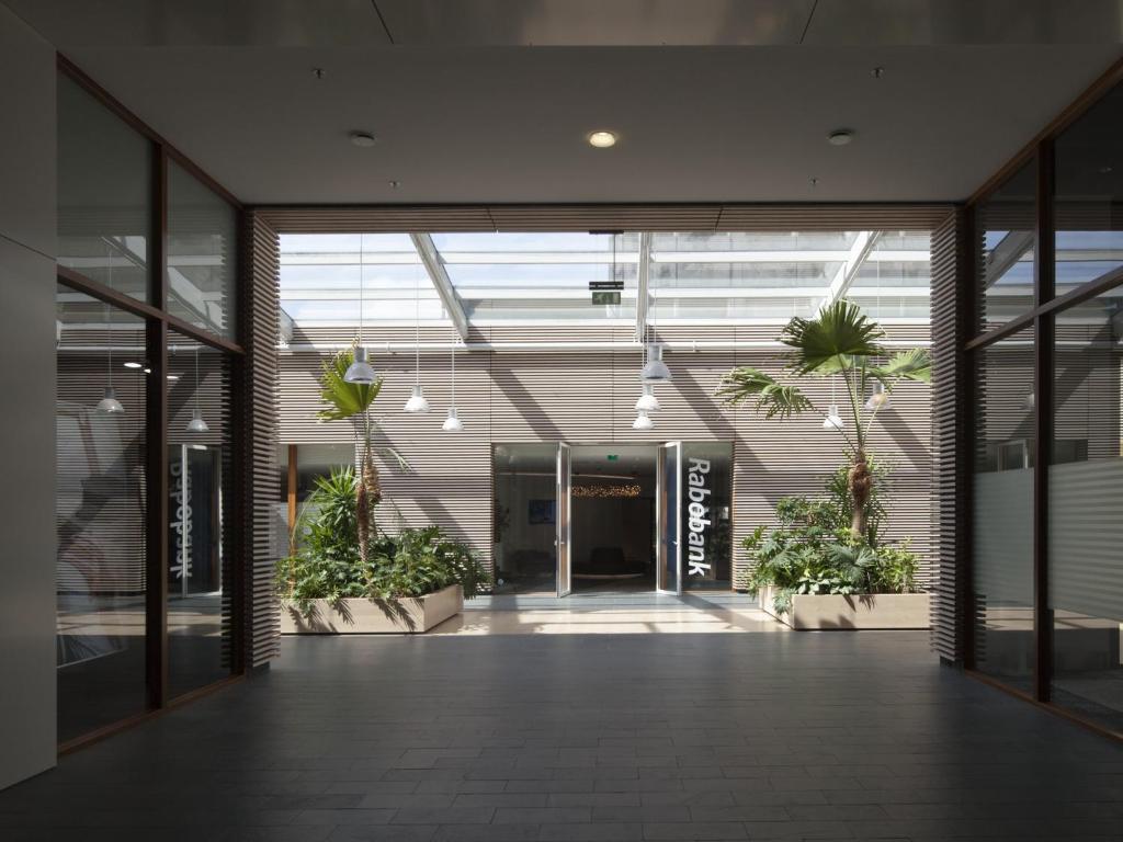 an empty hallway in a building with potted plants at easyHotel Amsterdam Zaandam in Zaandam