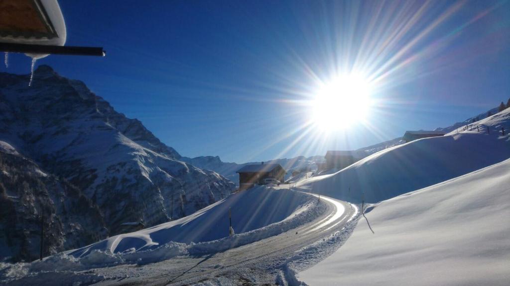 um sol está brilhando em uma montanha coberta de neve em Dem Himmel ein Stuck näher em Thalkirch