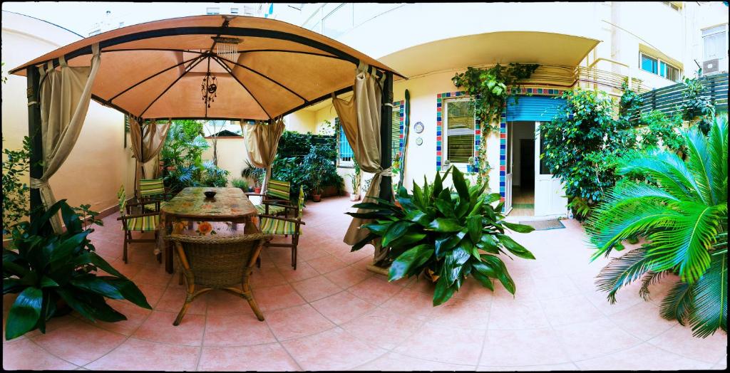 un patio con tavolo, ombrellone e piante di B&B Livingstone a Cagliari