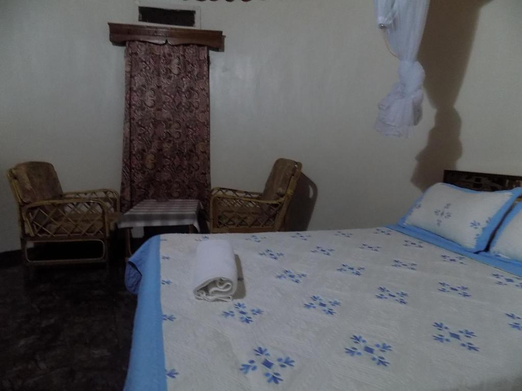 a bedroom with a bed with a blue comforter at Tooro Resort Hotel in Fort Portal