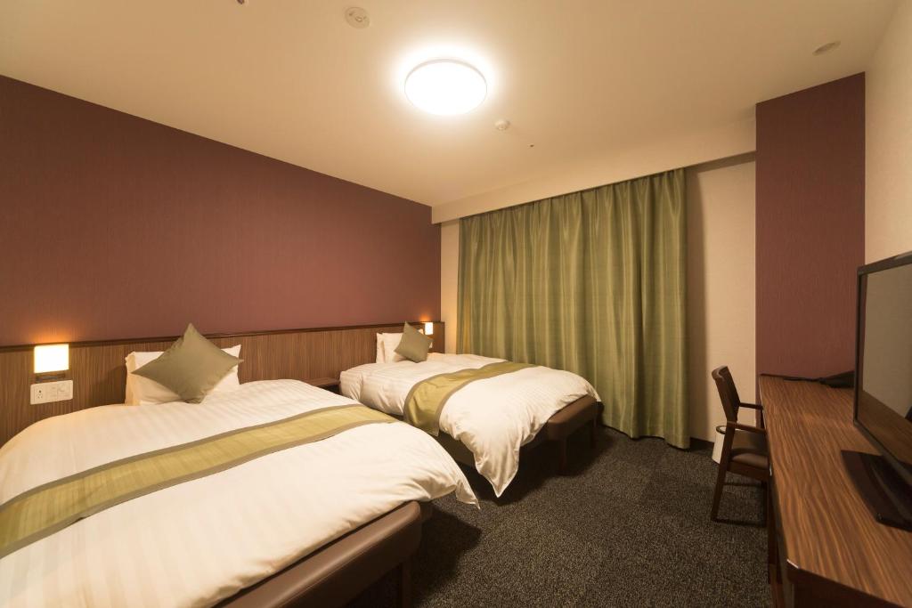 Postel nebo postele na pokoji v ubytování Myoujin-no-Yu Dormy Inn Premium Kanda