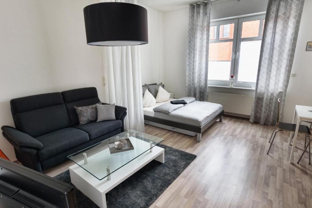 ein Wohnzimmer mit einem Sofa und einem Couchtisch in der Unterkunft City Apartment Aurich - Ostfriesland in Aurich