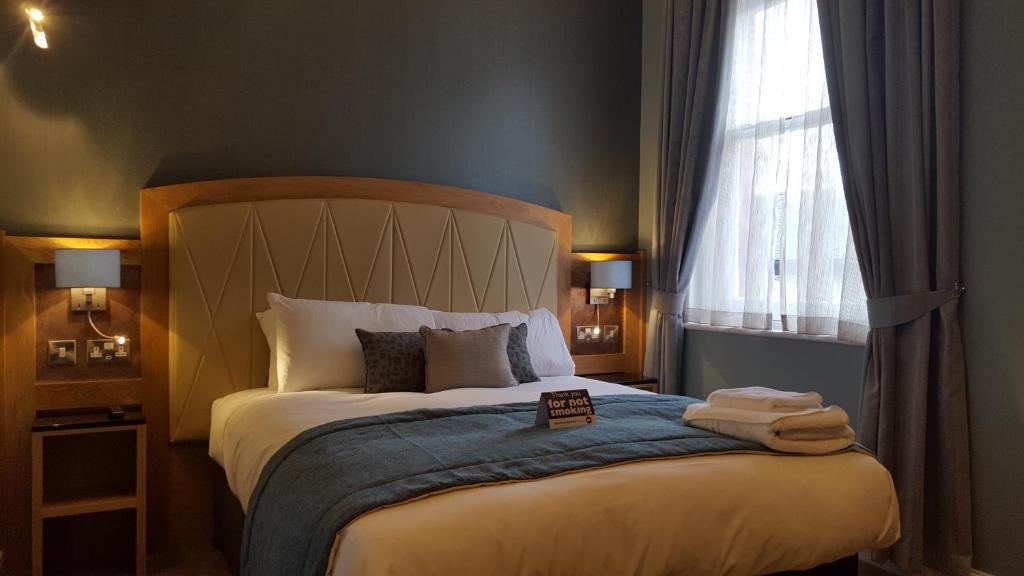 - une chambre avec un lit et des serviettes dans l'établissement The Bull & Stirrup Hotel Wetherspoon, à Chester