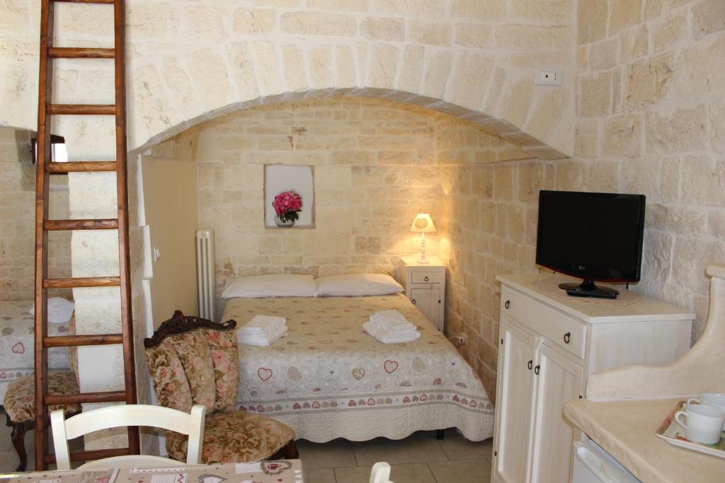 Dormitorio pequeño con cama y TV en Trullo Monte Grappa, en Alberobello