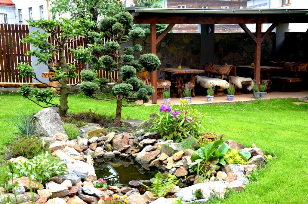 a garden with a pond in the yard at Apartmány Agáta Abertamy in Abertamy