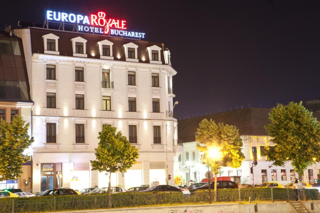 un gran edificio blanco con un letrero de neón. en Europa Royale Bucharest, en Bucarest