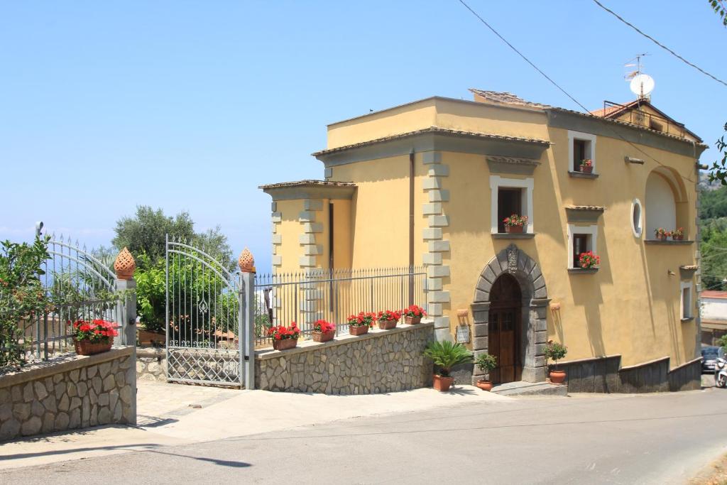 um edifício com uma cerca e flores sobre ele em Agriturismo Antico Casale Colli Di San Pietro em Piano di Sorrento