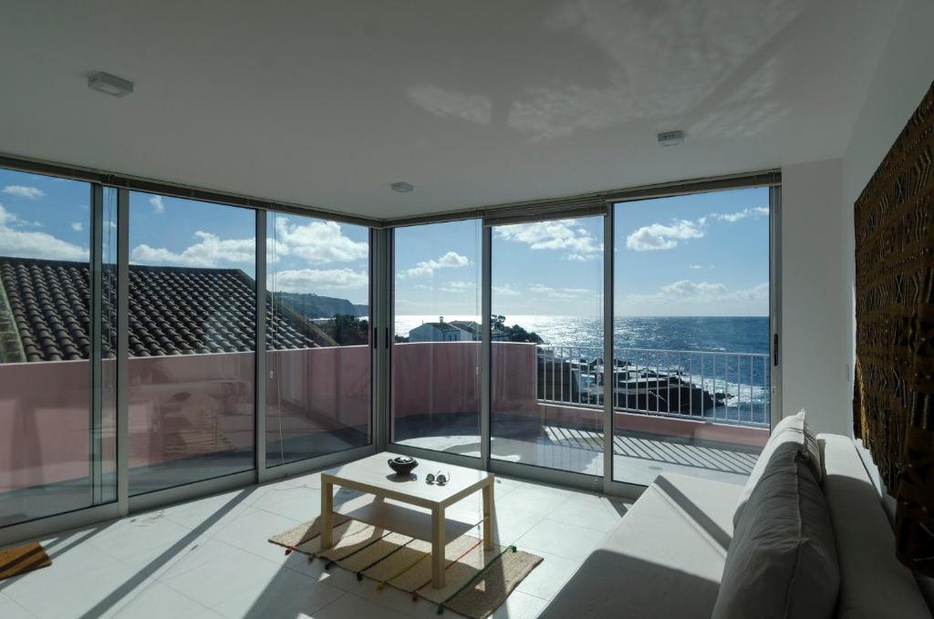 a living room with a view of the ocean at Casa Rosa-Porto dos Carneiros in Lagoa