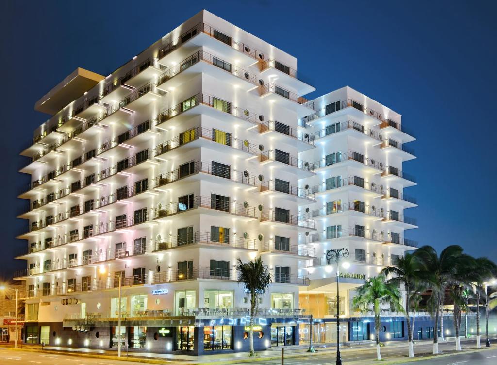 a tall white building at night at Emporio Veracruz in Veracruz