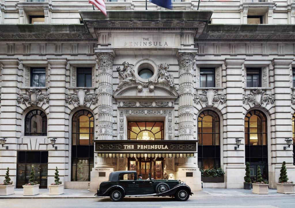 an old car parked in front of a building at The Peninsula New York in New York