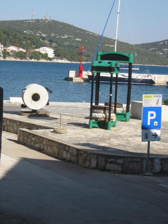 a parking sign in front of a body of water at Apartment Vidačak in Tisno