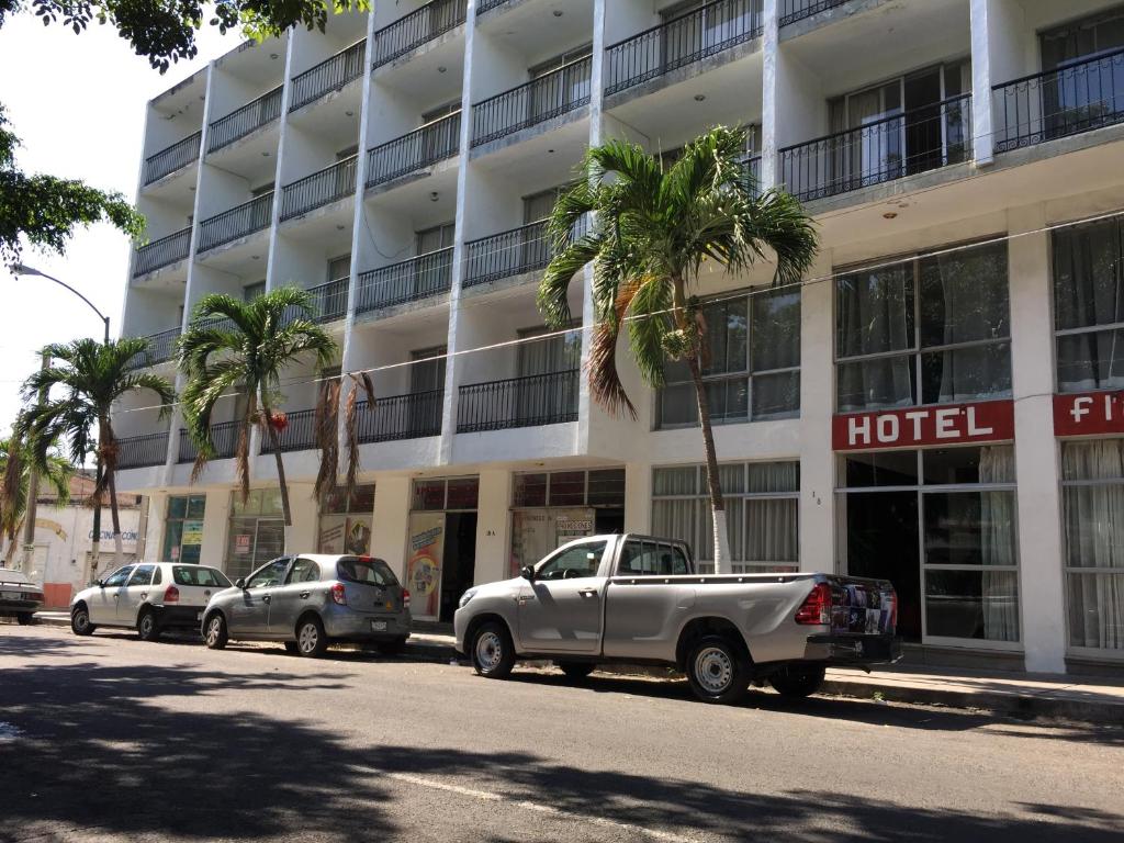 un hotel con coches estacionados frente a un edificio en Hotel Flamingos Colima, en Colima