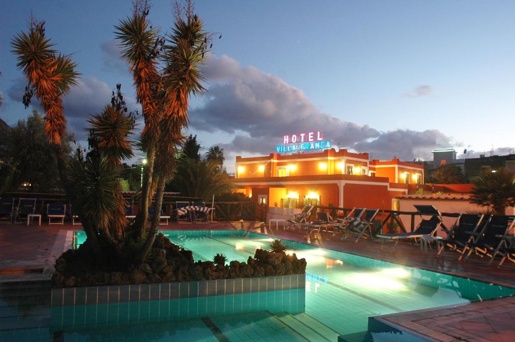um hotel com piscina em frente a um edifício em Hotel Villa Franca em Ischia