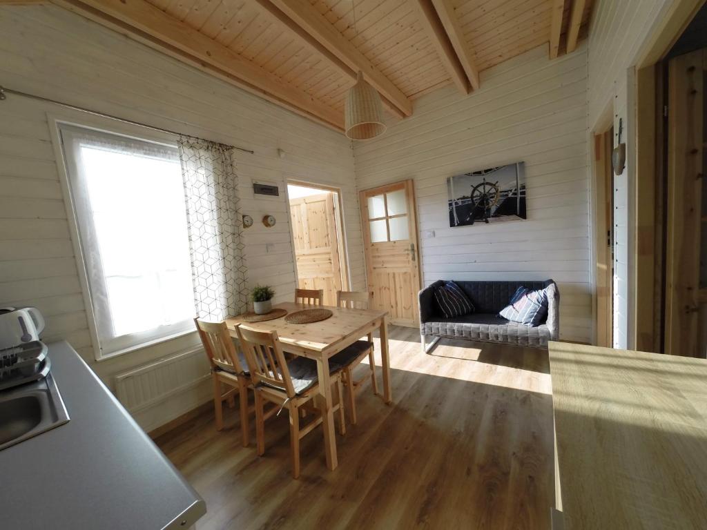 kuchnia i salon ze stołem i kanapą w obiekcie By The Sea Lodges w mieście Wrzosowo