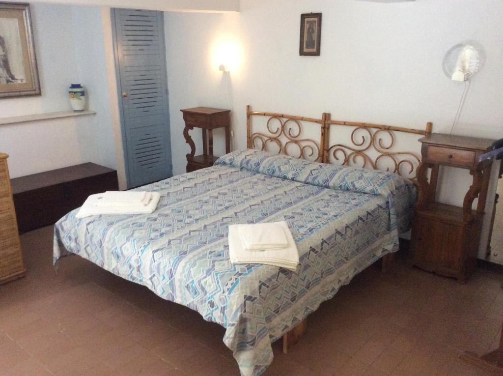 1 dormitorio con 1 cama con 2 toallas en Villino with Garden en Tropea