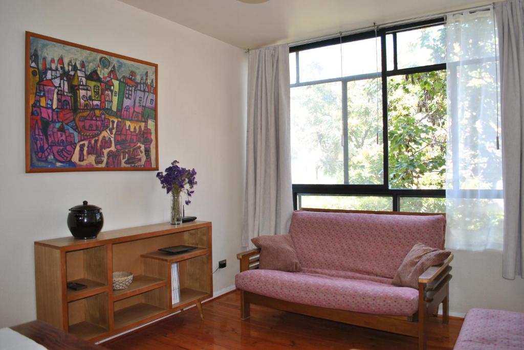 a living room with a couch and a window at Santo Domingo frente Bellas Artes in Santiago