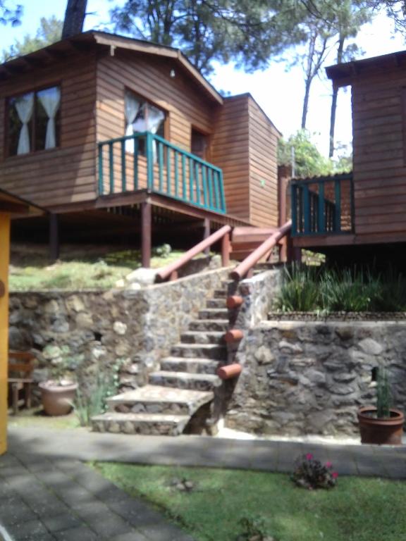 a house with a staircase leading up to a house at Cabañas Monte Alto Hotel Boutique in Valle de Bravo