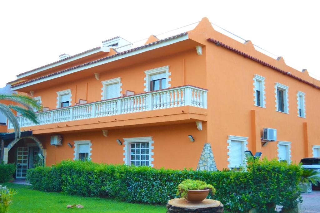 セッリーア・マリーナにあるHotel Costa Jonicaのオレンジ色の建物で、バルコニーが付いています。