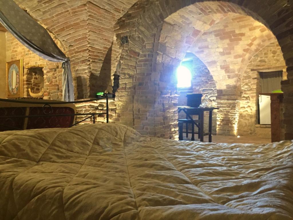 a bedroom with a large bed in a stone wall at Pantorano rooms in Spinetoli