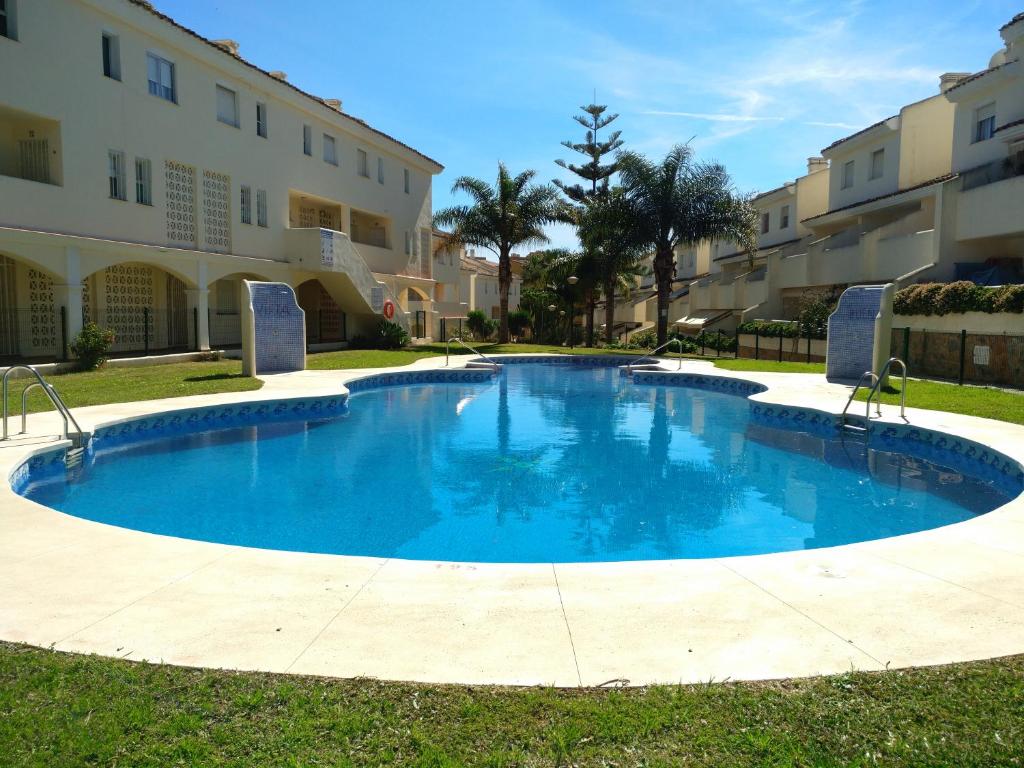 a large blue swimming pool in front of a building at Calahonda Buenavista in Mijas Costa
