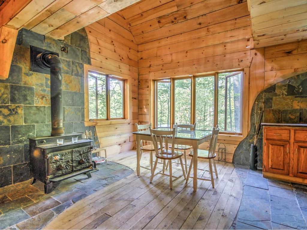 a dining room with a wood stove in a log cabin at Rafting Momentum in Bryson